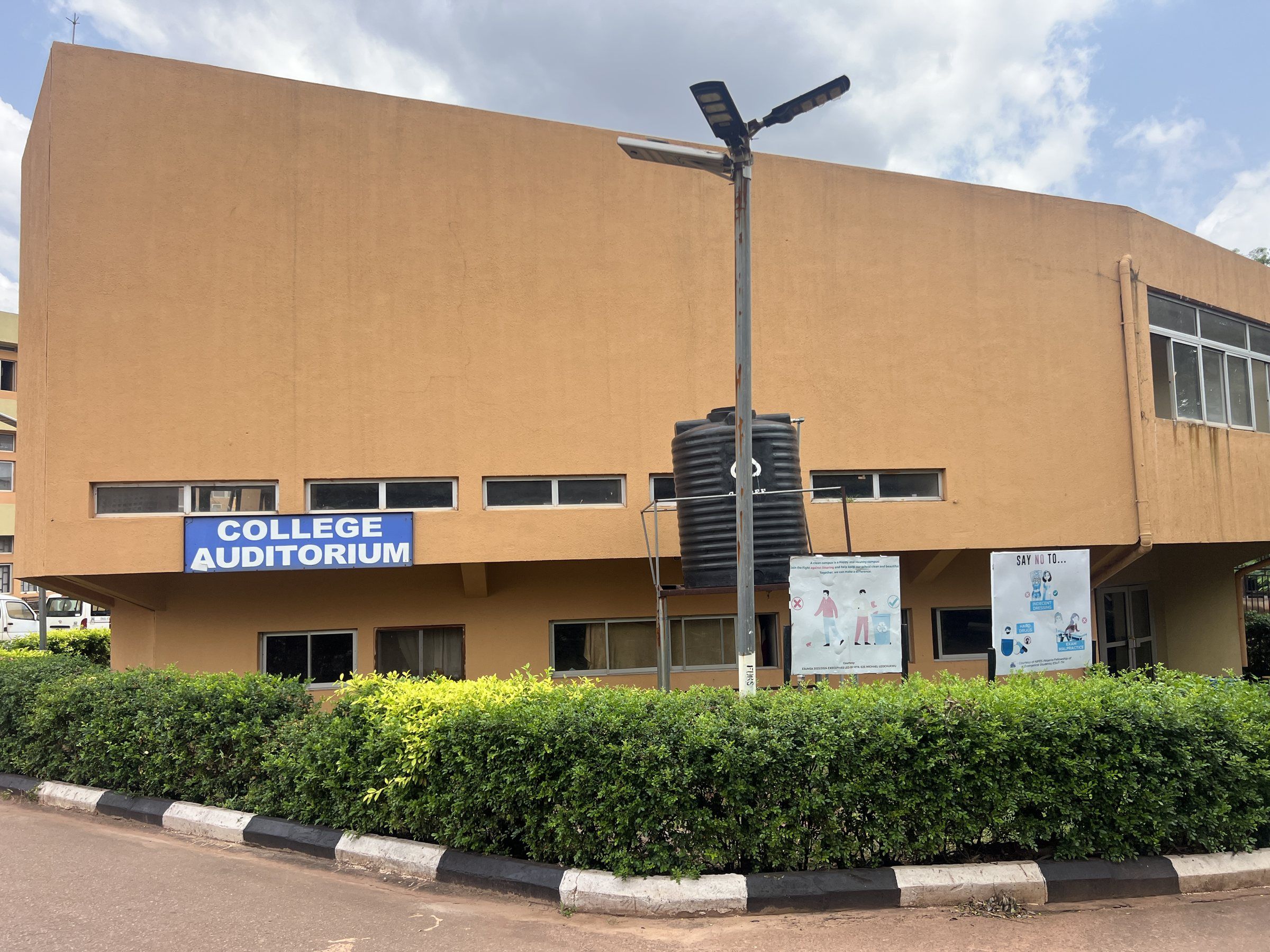 The College Auditorium seen from the road, with its name on a blue sign.