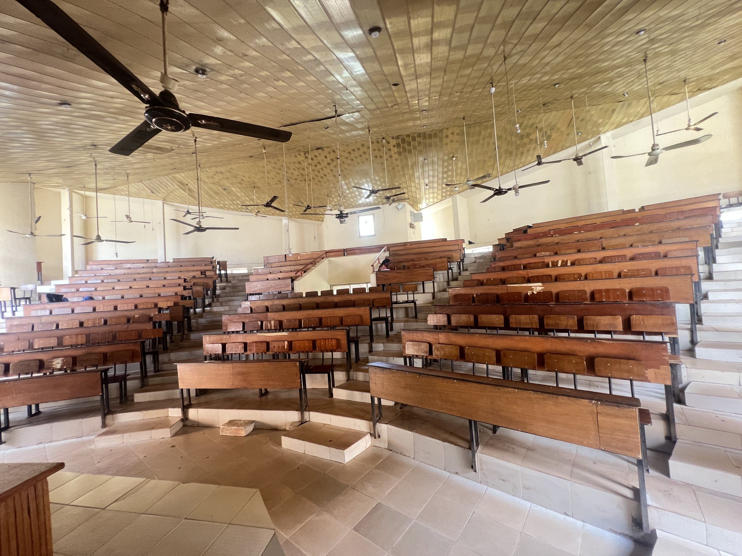 Tiered rows of wooden benches inside the College Auditorium.