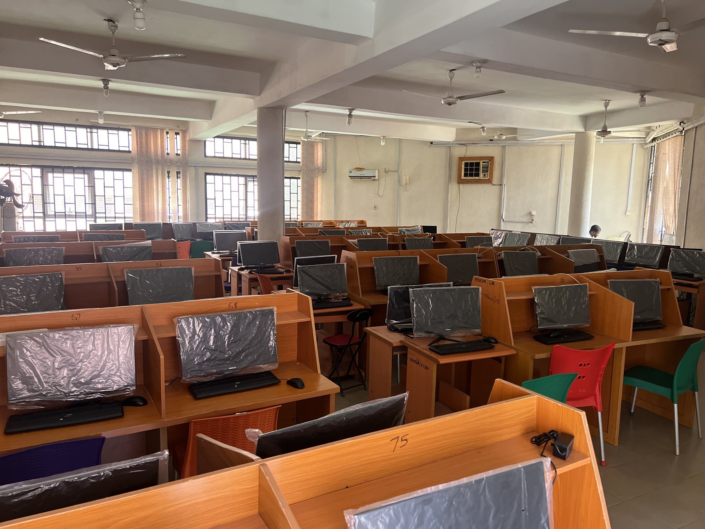 Rows of wooden study carrels with desktop computers in the college library.