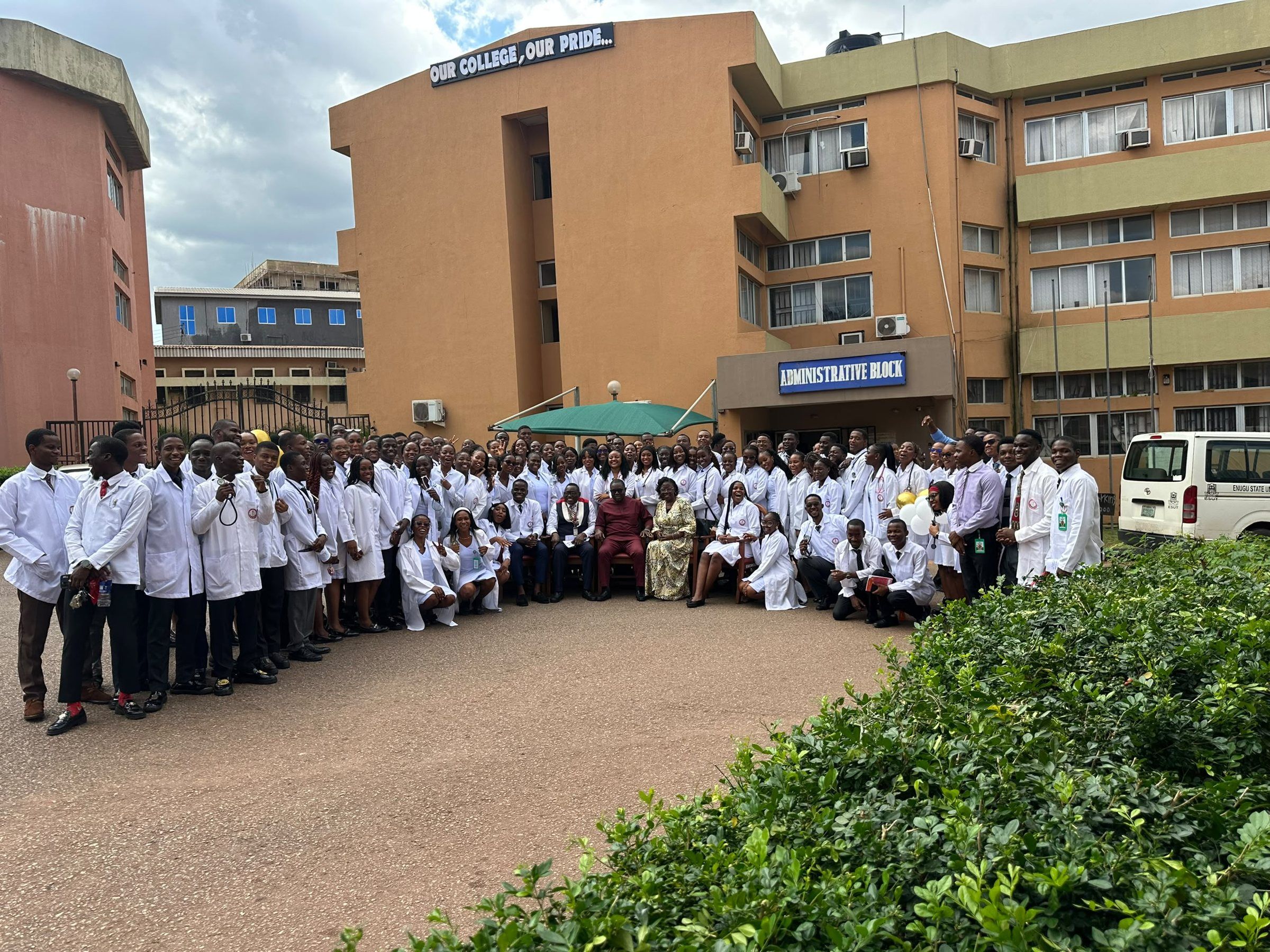 The Class of 2029 in white coats with college staff seated at the centre, in front of the Administrative Block.
