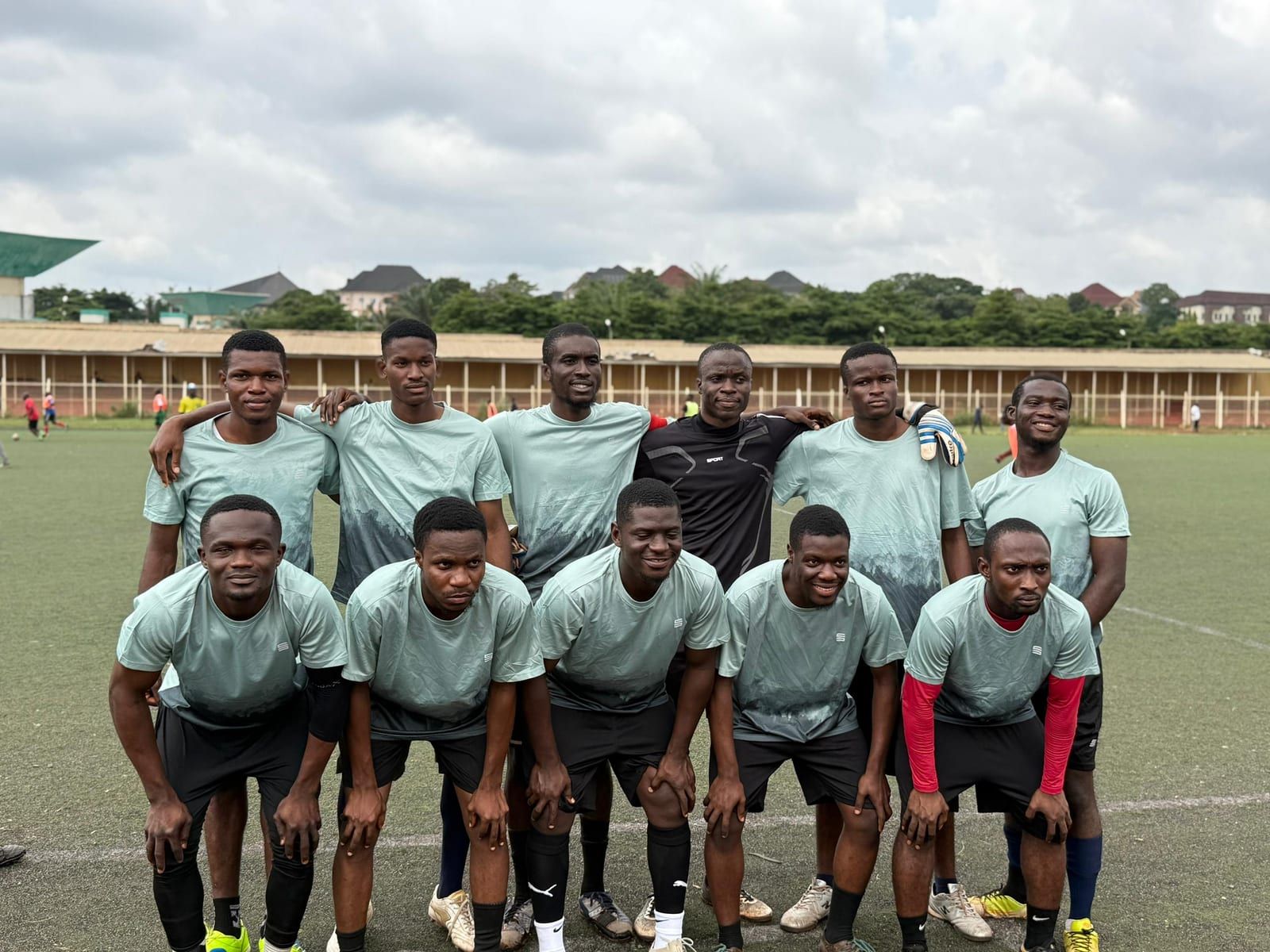 The ESUMSA football team in grey kits, posing in two rows on a pitch.
